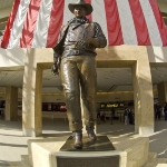 Achievement A nine-foot bronze statue of John Wayne at the entrance of the John Wayne Airport in Orange County, California. of John Wayne