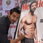 Achievement John Abraham signing the cover of Men's Health where he appeared in 2013. of John Abraham