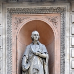 Achievement Statue of Smith built in 1867–1870 at the old headquarters of the University of London, 6 Burlington Gardens of Adam Smith