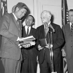Achievement American poet Robert Frost is presented with a medal by President John F Kennedy at the White House, in turn the president received a book of poems from Frost.  of Robert Frost