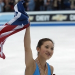 Achievement Michelle Kwan totes the stars and stripes as she takes a victory lap after taking the gold medal of World Figure Skating Championships at the MCI Center (later known as Capital One Arena) in Washington D. C. Photo by Doug Pensinger. of Michelle Kwan